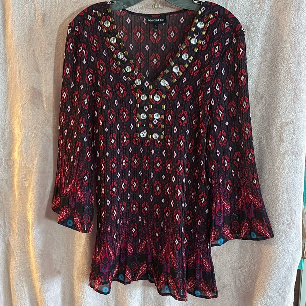 Red Patterned Top with Beaded Neckline. 3/4 length flared sleeves and flared hem